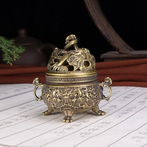 Detailed close-up of a vintage brass incense burner with intricate dragon carvings