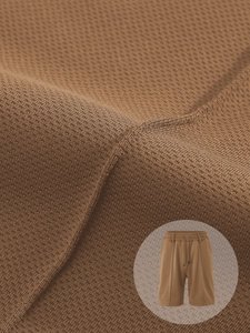 Detail of brown men's waffle knit shorts showing drawstring waist and fabric texture