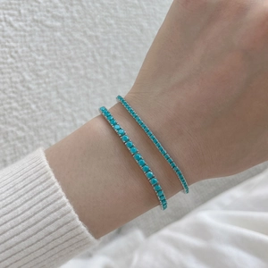 Detail view of 925 sterling silver tennis bracelets with green turquoise stones on wrist