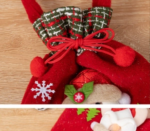 Detail of red Christmas gift bag showing plaid drawstring, ribbon bow and plush pom-poms