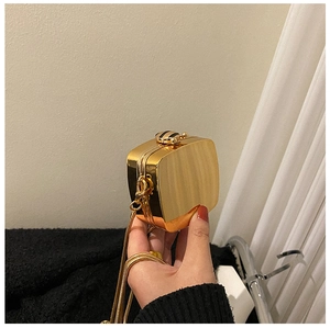 Glossy gold metal mini evening bag featuring a bee clasp and gold chain strap
