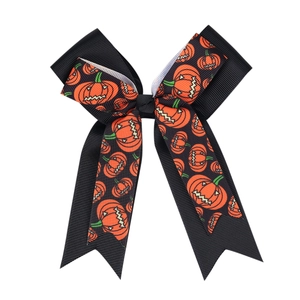 Detail of Halloween grosgrain ribbon bow with orange pumpkin prints and layered design
