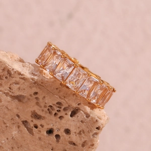 Macro view of 18K gold plated ring with square zircon stones on a natural stone base