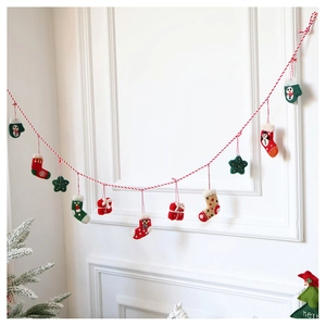 Close-up of handmade wool felt Christmas ornaments with red and green festive stockings