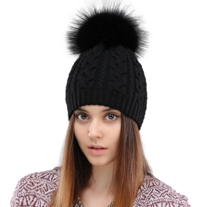 Women's black wool knit beanie with thick cable pattern and a large faux fur pompom