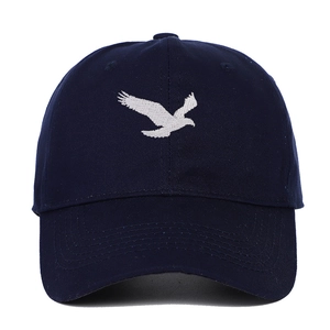 Détail de la broderie d'oiseau blanc sur une casquette de baseball en coton bleu marine