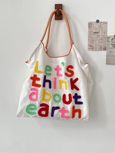 Detail of canvas tote bag with colorful Chenille embroidery and checkered strap
