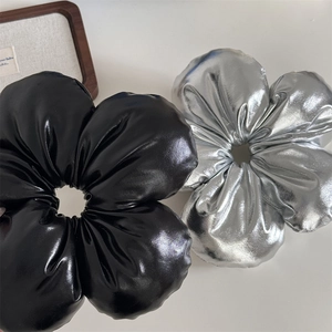 Metallic large 3D flower scrunchies in black and silver finishes on white background