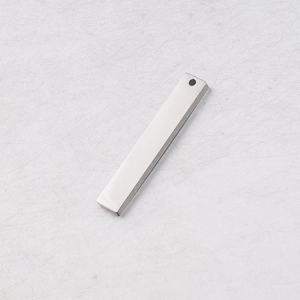 Macro shot of silver rectangular stainless steel bar pendant with hole on white background