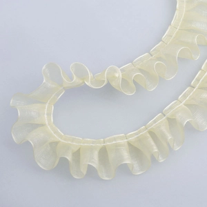 Close-up of 2.5cm beige organza pleated lace ribbon with wavy edge for DIY crafts