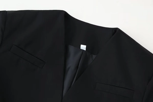 Detail of elegant black V-neck blazer with puff sleeves and neat stitching details
