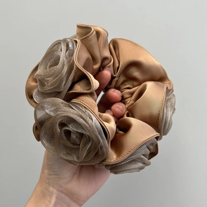 Brown champagne satin scrunchie with layered tulle roses shown being held by a hand