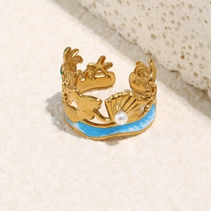 Detailed macro view of 18K gold plated starfish and shell ring with blue enamel and pearl
