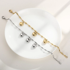 Minimalist stainless steel heart bracelets in gold and silver finish on white plate