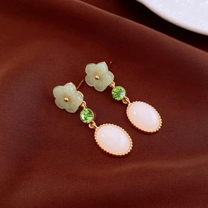 Elegant natural stone earrings with butterfly flower design on dark brown satin background