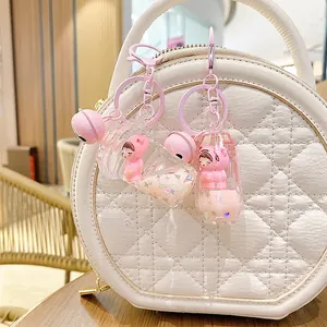 Pink liquid quicksand bear keychain with heart sequins and bell on a white bag