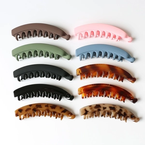 Detailed flat lay of eight assorted matte and tortoise banana hair clips on white background