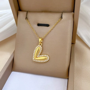 Detail view of heart-shaped gold necklace with sparkling zircon pave in a gift box