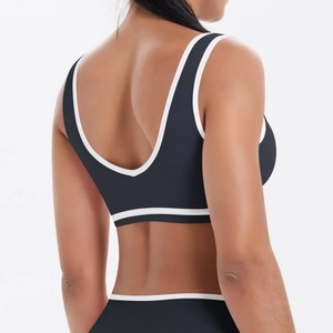 Vue détaillée du dos d'un brassière de sport noire avec passepoil blanc pour le yoga