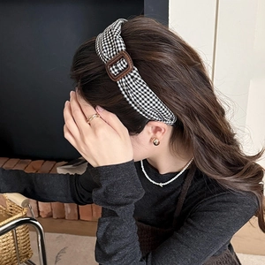 Femme portant un serre-tête vintage à carreaux noir et blanc avec boucle carrée brune