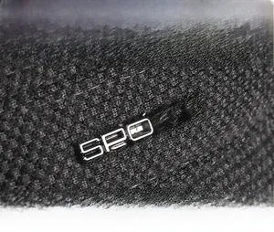 Detail of black woven texture fabric featuring a metallic silver SPORT logo badge
