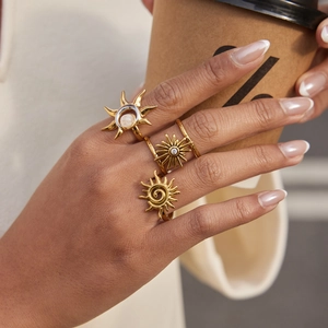 Ensemble de trois bagues dorées 18 carats à motifs solaires portées par un mannequin