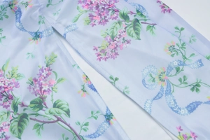 Detail of light blue floral dress fabric featuring side slit stitching and soft texture
