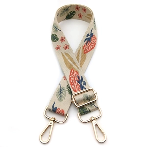 Close-up of ethnic floral embroidery strap with gold hooks and adjustable buckle