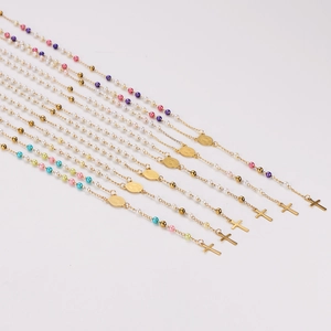 Colorful pearl and gold stainless steel cross pendant necklaces set on white background