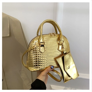 Detail of golden crocodile embossed shell bag with matching mini coin purse and strap