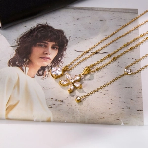 Detail of gold flower zircon necklace set with layered chains and sparkling floral pendants