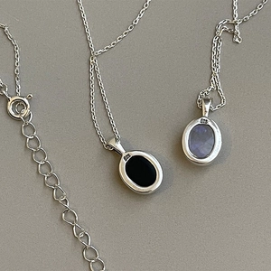 Detail of 925 sterling silver stamp on oval gemstone pendants with fine chain links