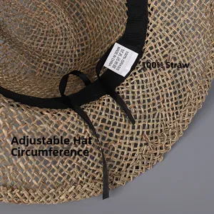 Detail view of woven seagrass straw hat texture with adjustable black inner ribbon