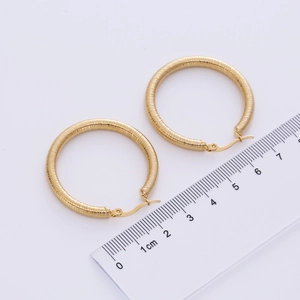 Detailed view of 18K gold plated stainless steel hoop earrings with ribbed texture and ruler