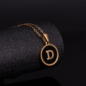 Vue macro du pendentif lettre D en or 18 carats avec émail noir sur fond sombre