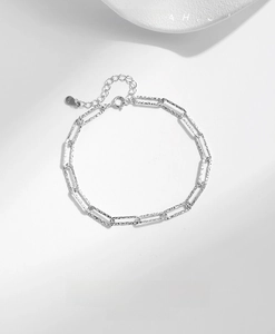 Macro detail of S925 sterling silver paperclip chain with hammered texture and S925 stamp