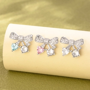 Chic silver bow earrings with dangling heart and round gemstones in blue pink and clear