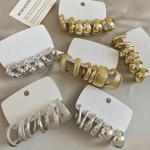 Minimalist gold and silver earring set with textured and smooth geometric metal designs