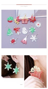 Gros plan de boucles d'oreilles de Noël à paillettes en formes de flocon et de sapin
