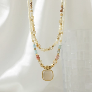 Layered natural stone beaded necklace with a gold-framed cream square gemstone pendant