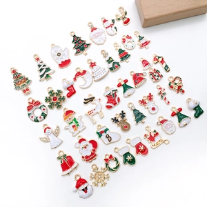 Macro shot of assorted Christmas enamel charms featuring Santa, reindeer, and snowflakes