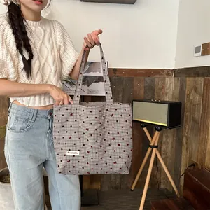 Détail du sac cabas en toile avec pois rouges et motifs de broderie en forme de nœud