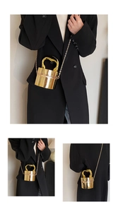 Detailed close-up of golden cylindrical acrylic bucket bag with metallic chain and handle