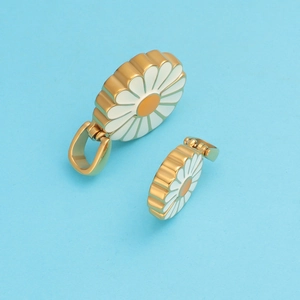 Detail view of golden sunflower daisy charms with white petals on blue background