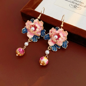 Detailed close-up of vintage flower earrings with pink enamel, pearls and gold tassels