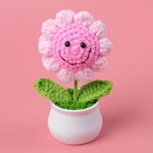 Handmade crochet pink flower in a white pot with a cute smiling face design