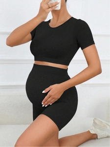 Detail of ribbed knit black maternity yoga set featuring high-waisted seamless biker shorts