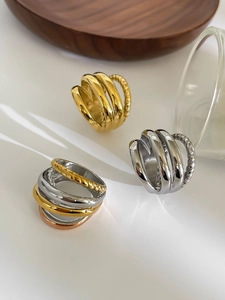 Detailed macro view of multi-layer 18K gold-plated rings with twisted texture finish
