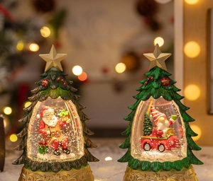Close-up of Christmas tree snow globe featuring Santa and Gnome figures with warm LED light