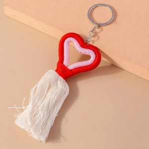 Detailed view of handmade knitted heart keychain with red fringe and silver metal ring